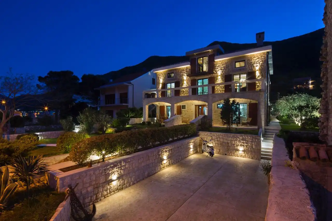 Villa Prčanj illuminated at night with Mediterranean garden and stone facade