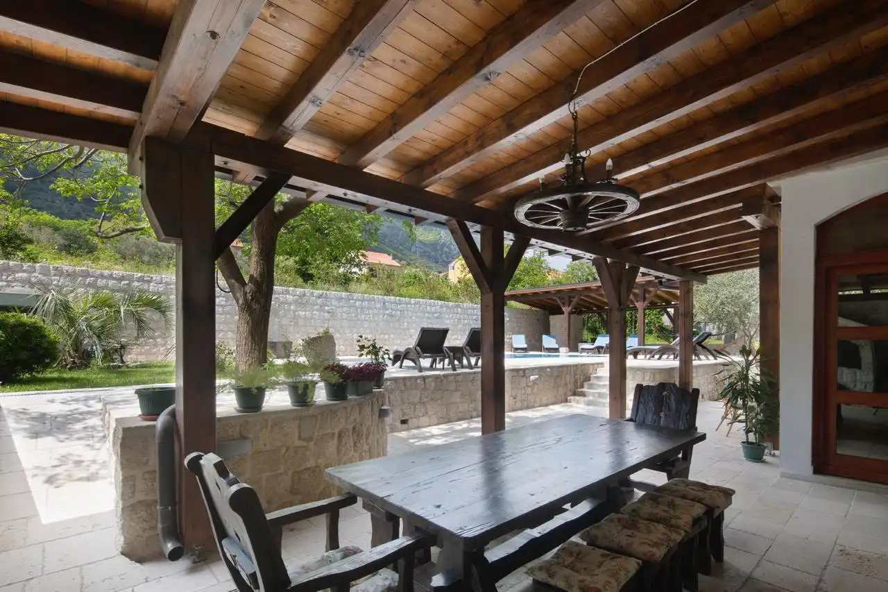 Rustic outdoor dining area under a wooden pergola – Villa Prčanj